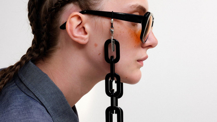 Model wearing chunky black eyewear chain in black acetate making a bold look.
