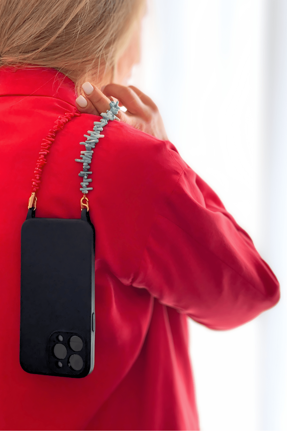 Model holding a smartphone with the Bay Play Summer Gemstone Phone Strap, showcasing the vibrant beads and functionality.