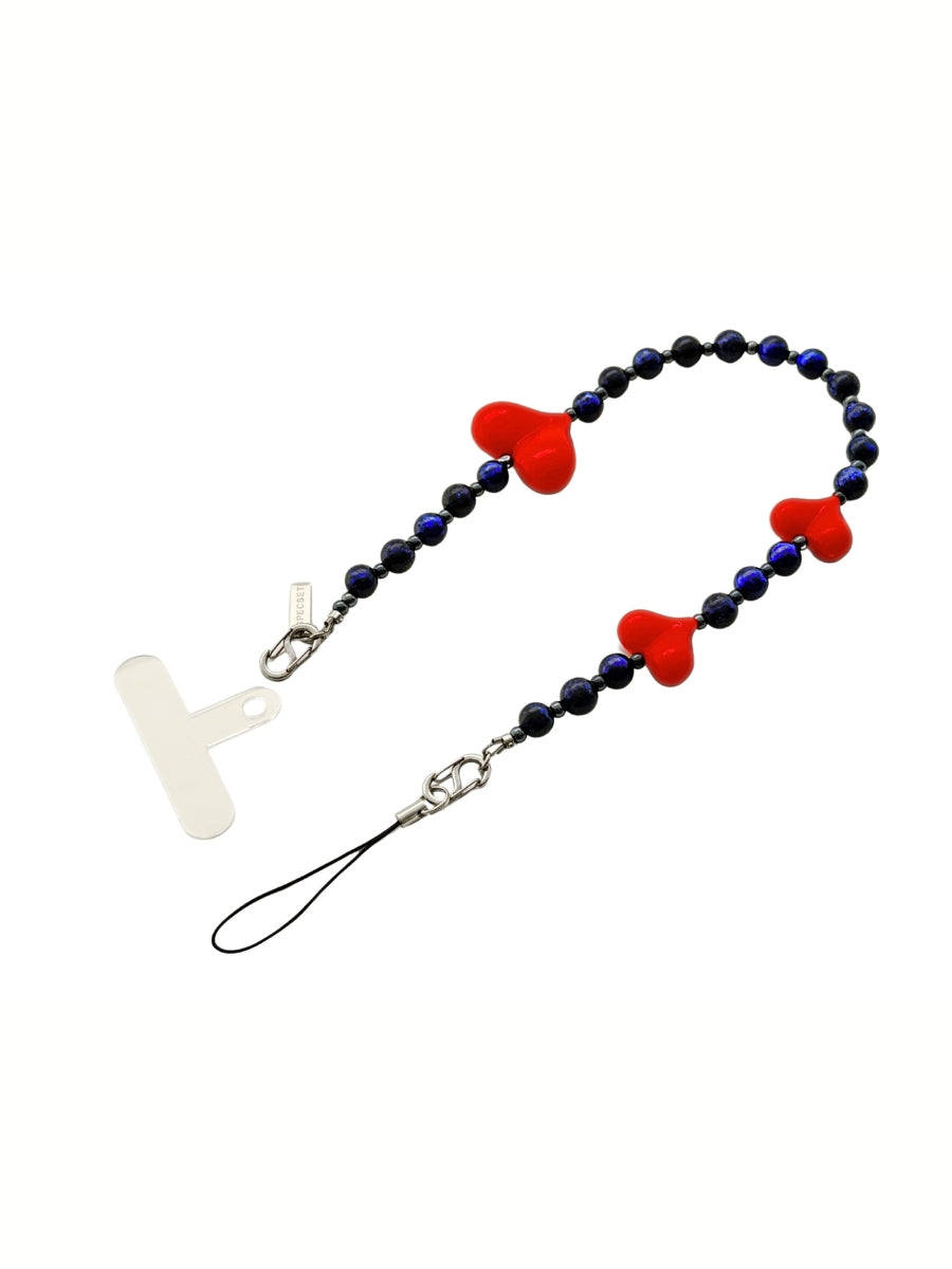 A beaded phone strap featuring dark blue faceted beads, three red heart-shaped beads, a silver metal, and a white silicone patch, shown on a plain white background.
