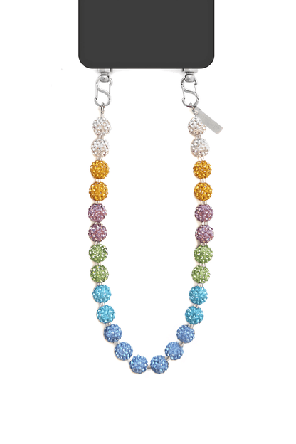 Phone resting on a surface with the strap draped around it.