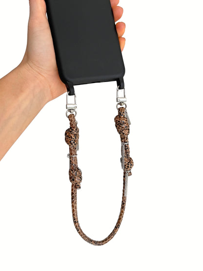 A hand holding a black smartphone with a brown leather strap attached by silver metal clips, shown against a plain white background.