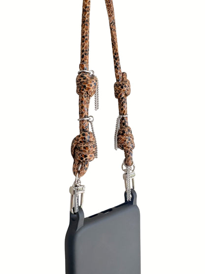 A black smartphone with a brown leather strap attached by silver metal clips, close-up.