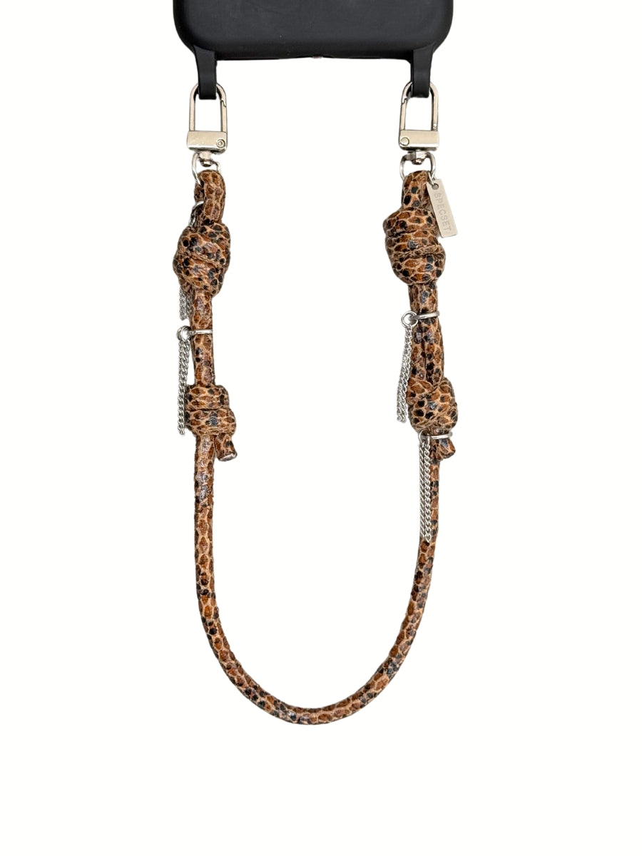 A brwon leather strap accessory with knotted details and silver-tone hardware, shown hanging against a plain white background.