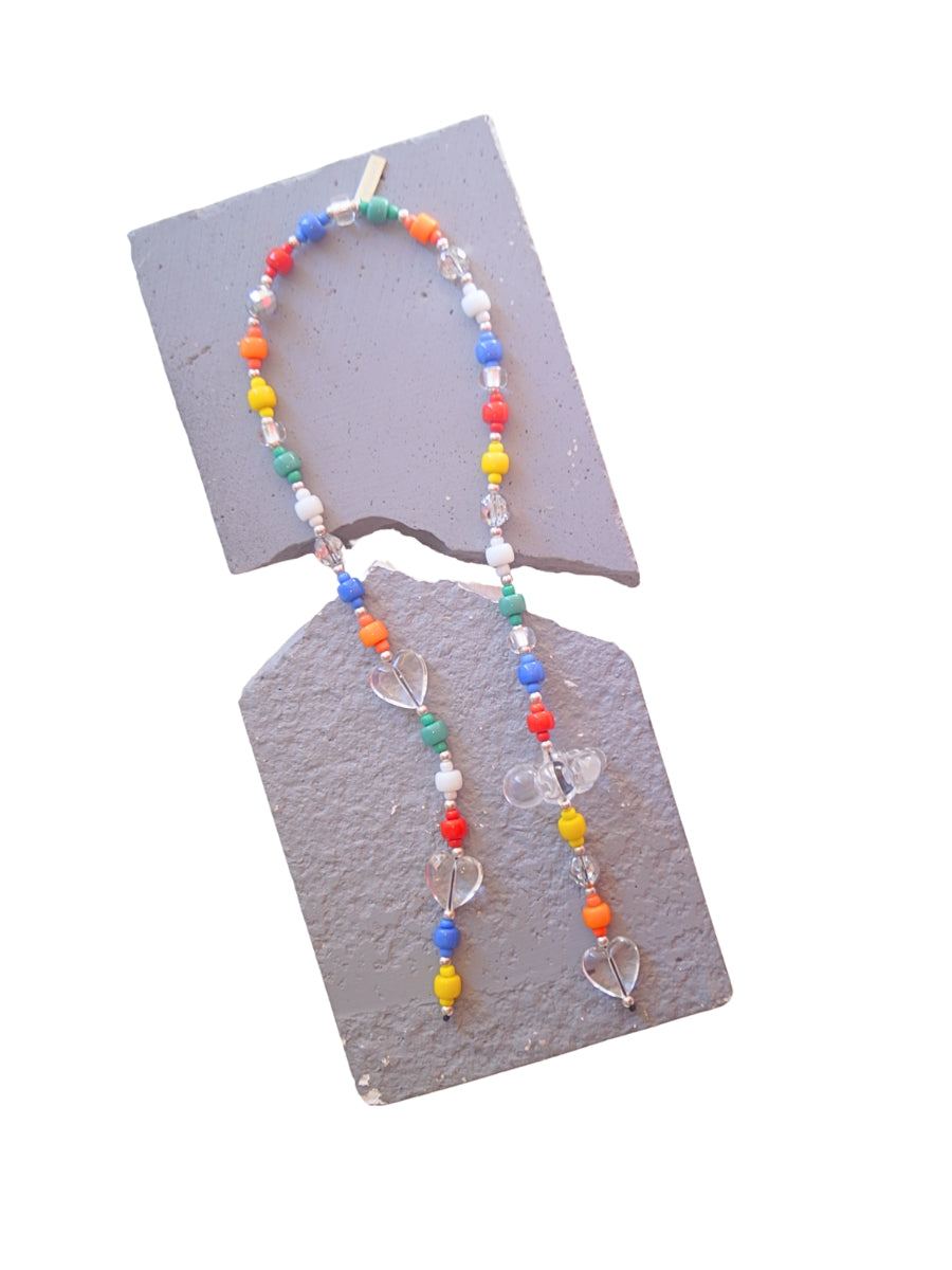 A beaded handbag charm with colorful round beads in red, orange, yellow, green, blue, and white. Clear heart-shaped beads and a cloud charm accent the accessory.