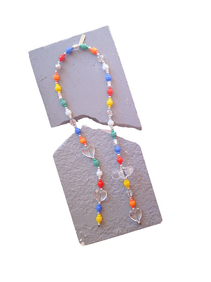 A beaded handbag charm with colorful round beads in red, orange, yellow, green, blue, and white. Clear heart-shaped beads and a cloud charm accent the accessory.