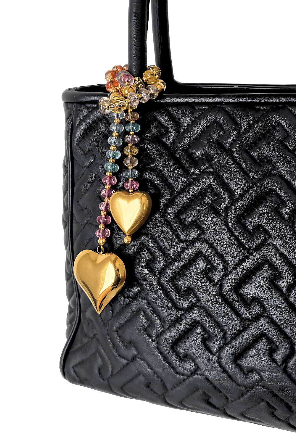 Colorful Swarovski crystal bag charm  
with gold hearts on a black handbag.