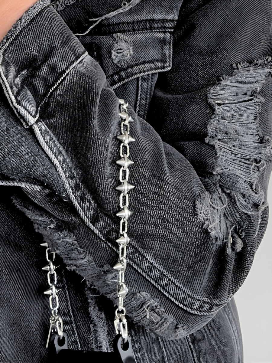 FINE CUT spike phone chain worn on the wrist with a black phone case.