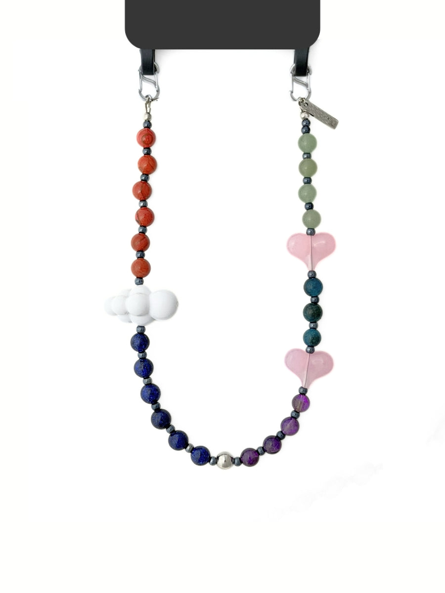 Playful heart beaded phone strap attached on a black phone case with grips.