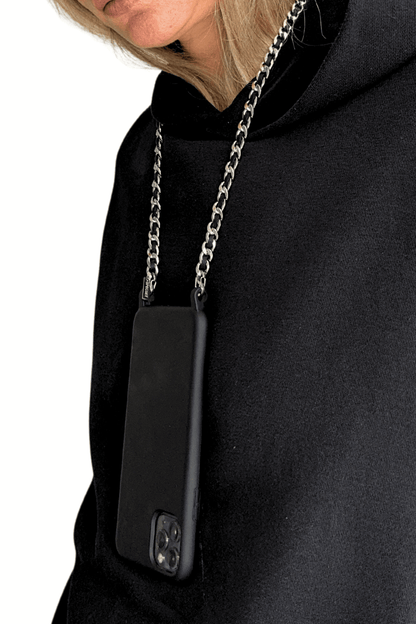 Woman wearing a black hoodie with a phone case attached to the Iconic Phone Chain.
