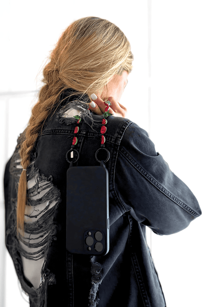 Model holding Juicy Crush strap attached to a black phone case.