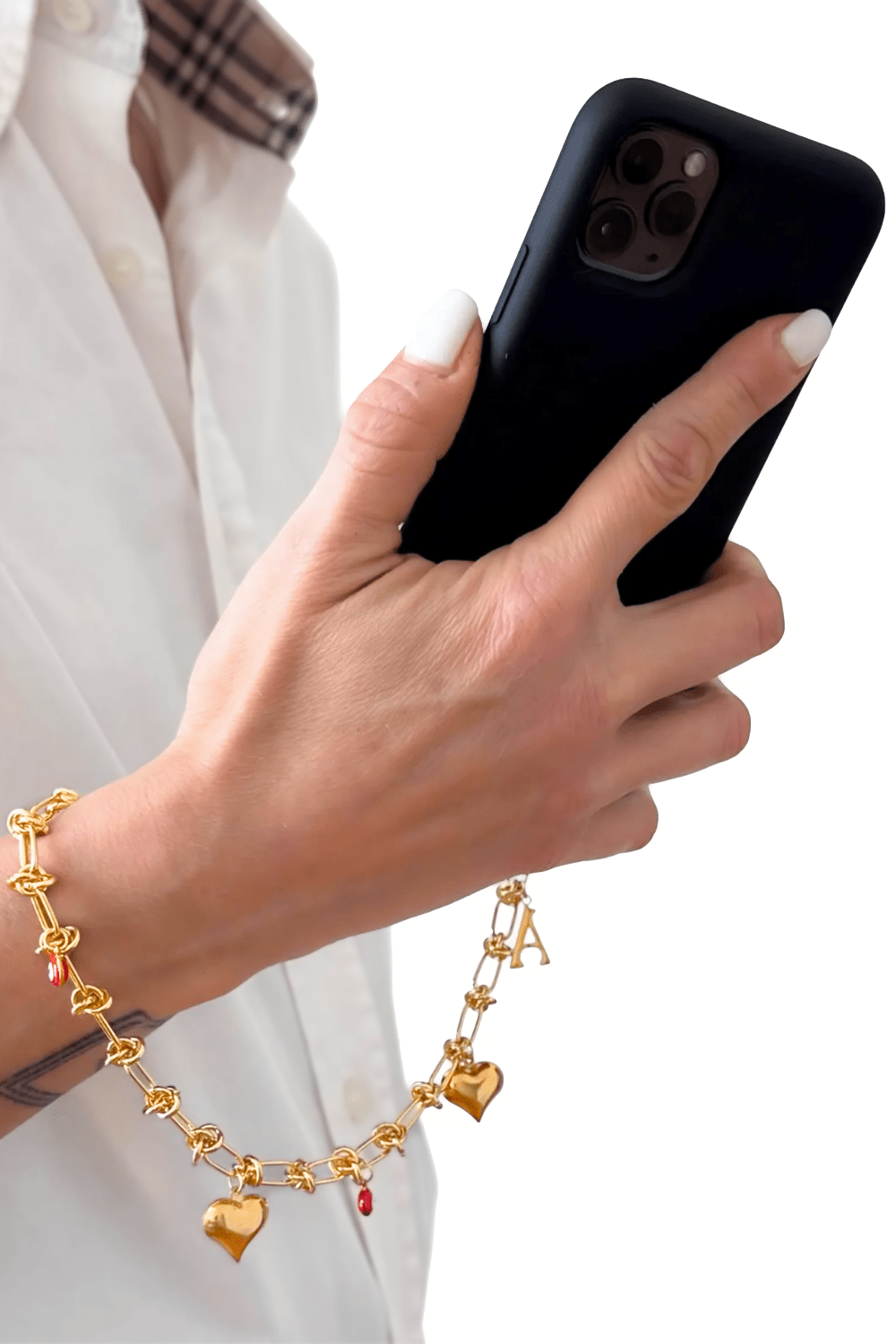 Woman holding a phone, wearing the Lover's Link gold chain as a wrist phone chain, showcasing the heart charms and initial personalization.