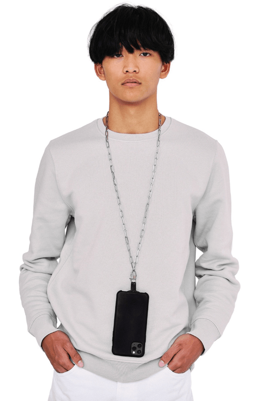 Person wearing a gray sweatshirt with a black phone case and a silver chain lanyard on a white background
