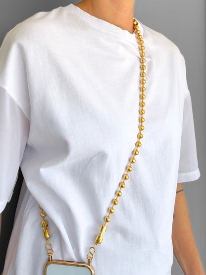 Play Call gold crossbody ball chain phone strap styled hands-free on a model.