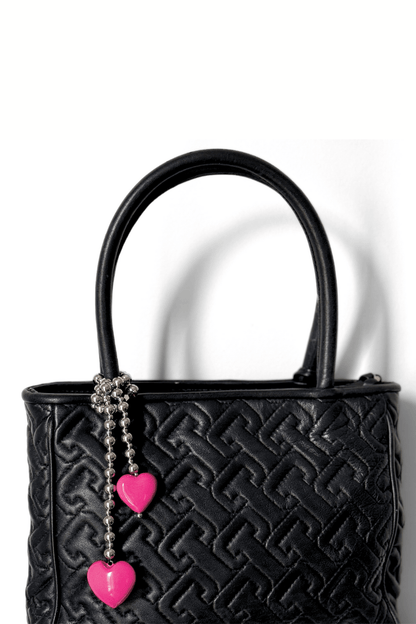 Pink hearts beaded bag charm on black bag.