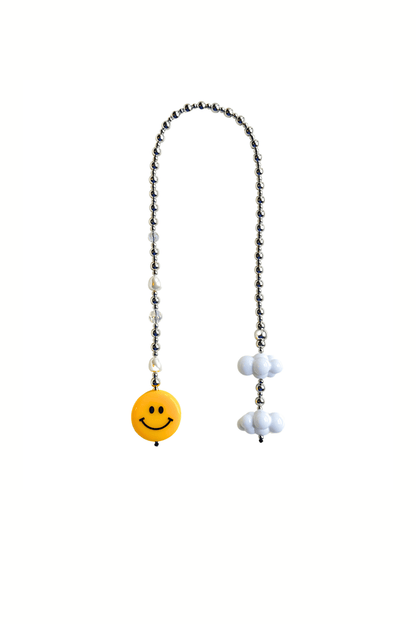 SMILEY beaded bag charm with smiling face and clouds on white background.

