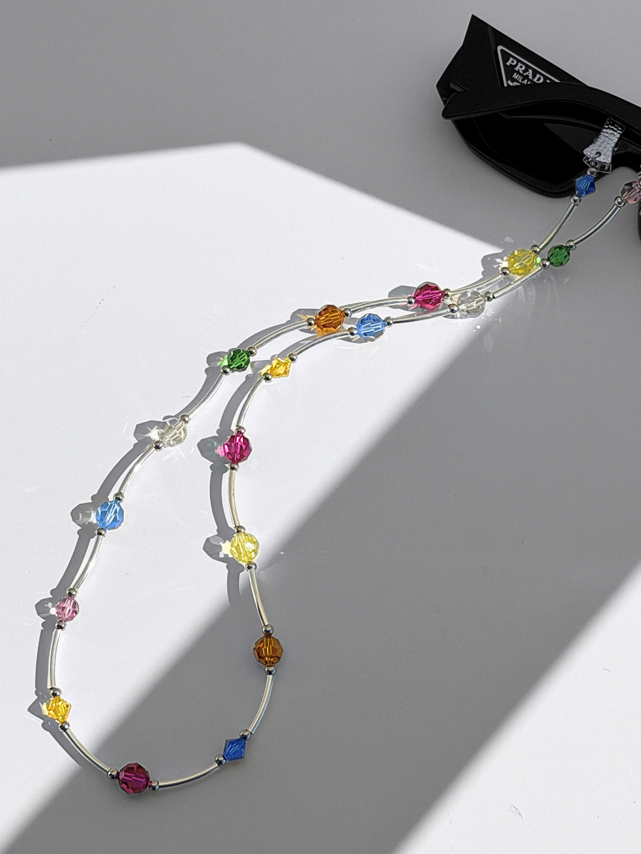 SOCIALITE Eyewear Strap with multi-colored Swarovski crystals and silver bars attached to sunglasses.
