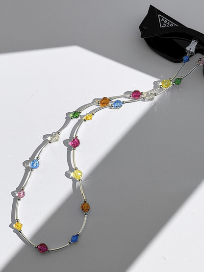 SOCIALITE Eyewear Strap with multi-colored Swarovski crystals and silver bars attached to sunglasses.