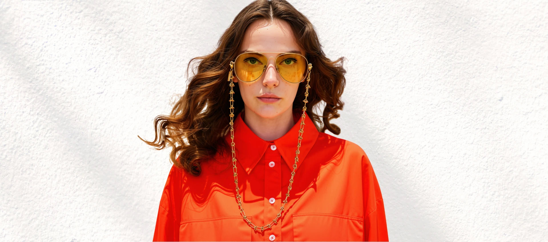 Model wearing the SPECSET Lyon gold eyewear chain with orange shirt
