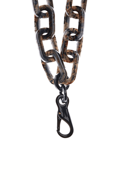 Close-up of the STATELY Phone Necklace, featuring the gray tortoise-shell pattern on the chunky acetate chain and the black acrylic clasp.