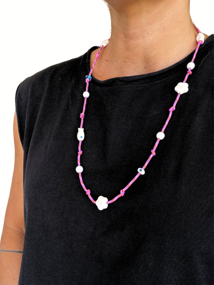Pink beaded eyewear strap worn as a necklace by a woman.